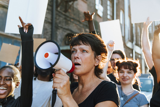 Frau mit Megaphone auf Demonstration Rawpixel via Getty Images