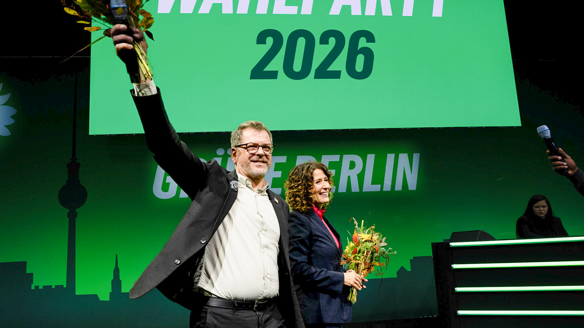 Werner Graf und Bettina Jarasch stehen auf der Bühne der Wahlparty nach der AGH-Wahl 2026