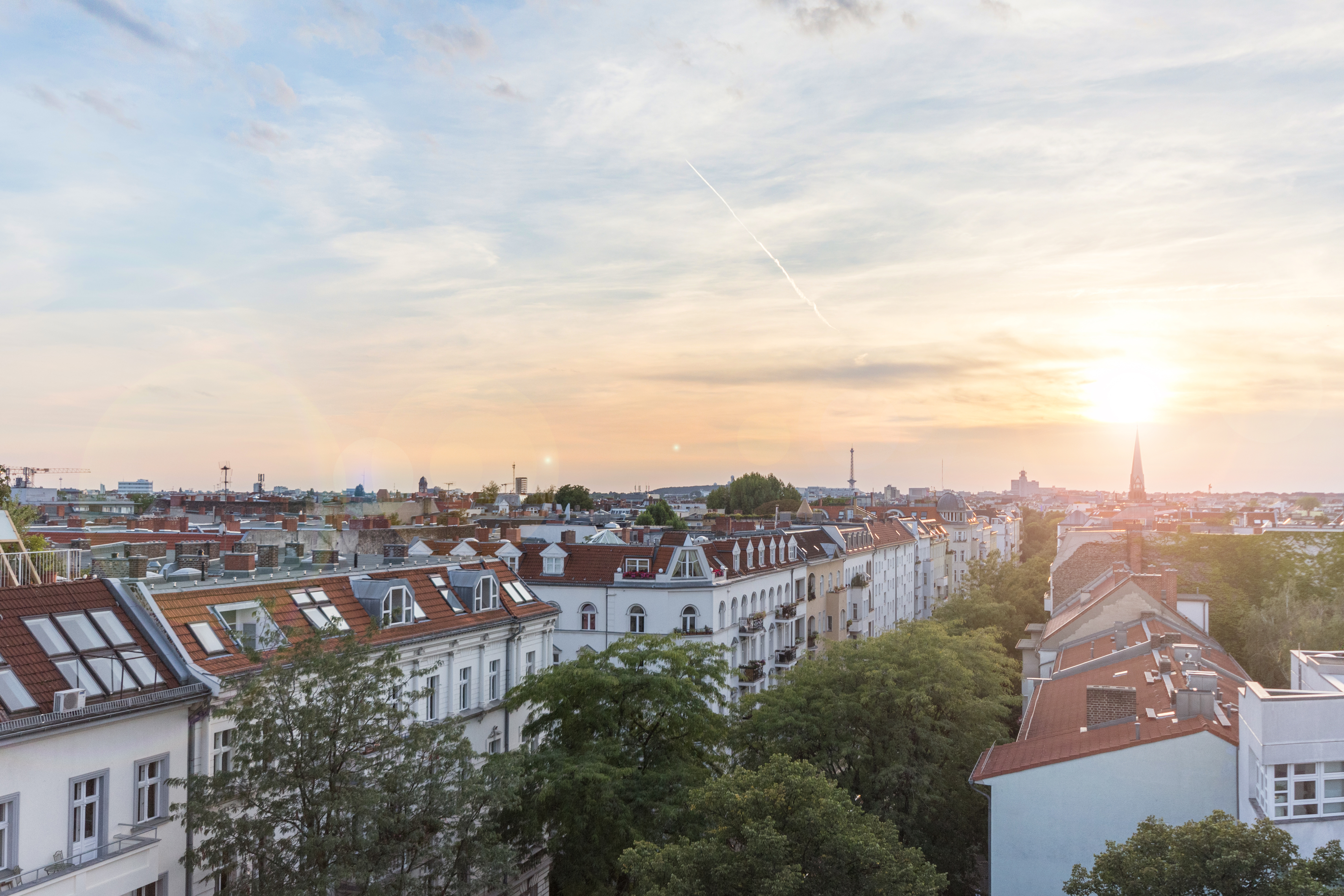 Ein Panoramabild von Berlin, im Vordergrund ist eine Straße mit Bäumen und Wohnhäusern zu erkennen hanohiki via Getty Images