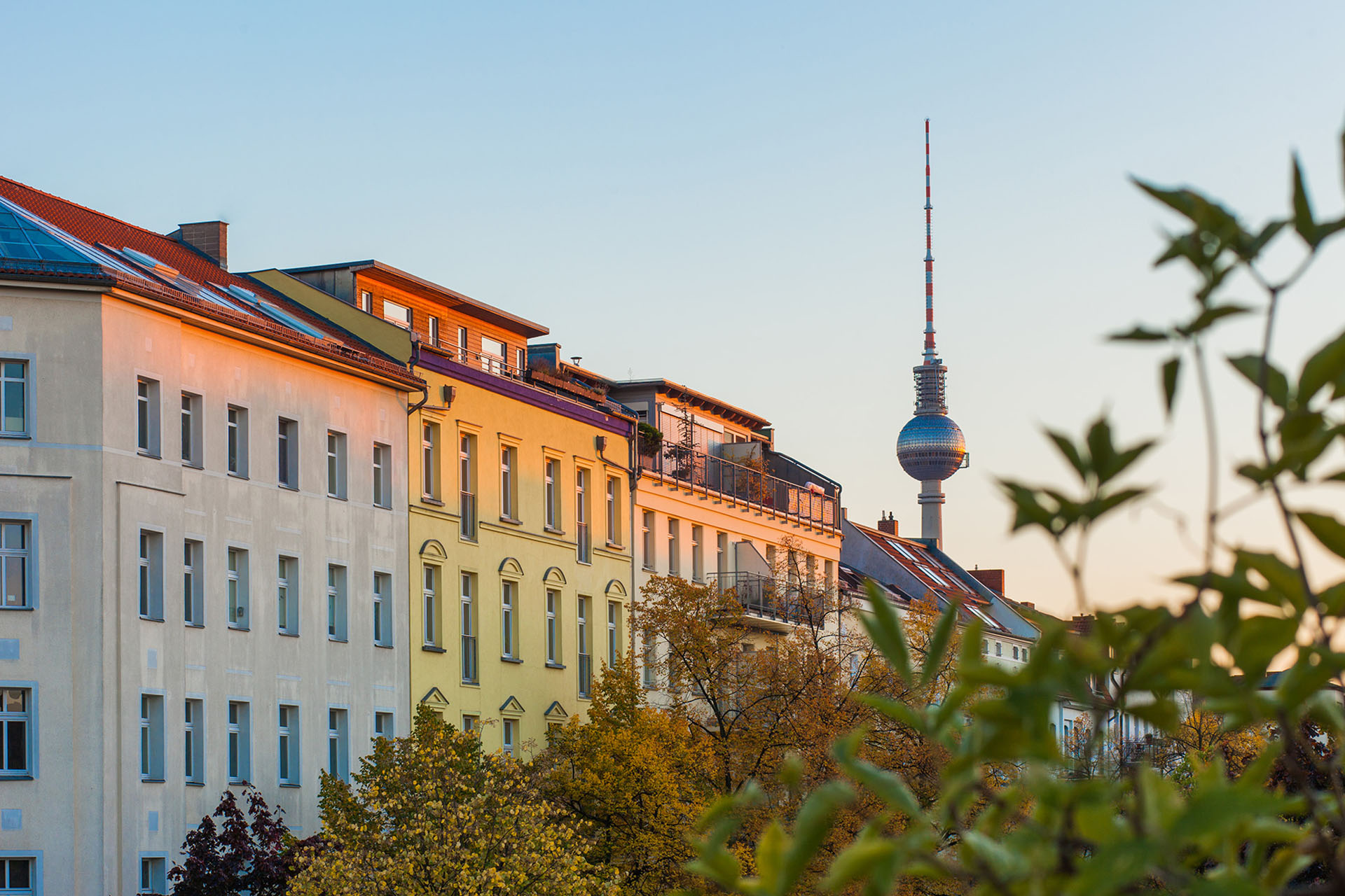 Ein Straßenzug mit Berliner Altbauten, im Hintergrund sieht man den Fernsehturm, die Sonne scheint.  Foto: Berlin Foto