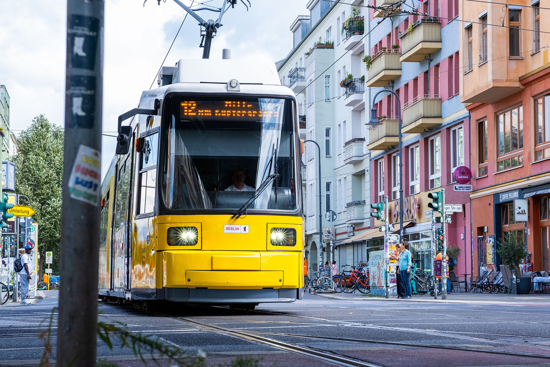 Eine Berliner Tram fährt durch die Straßen, sie ist von vorne zu sehen und fährt auf Schienen über Kopfsteinpflaster durch Berlin.  Foto: Bündnis 90/Die Grünen Berlin