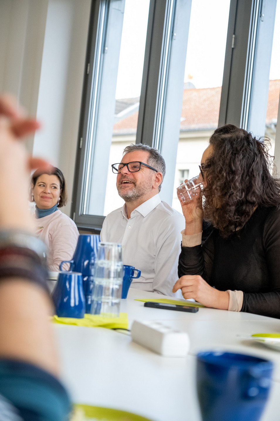 Ein Bild beim Brunch in der Berliner Landesgeschäftsstelle, Werner Graf sitzt an einem Tisch und spricht mit Besucher*innen. 