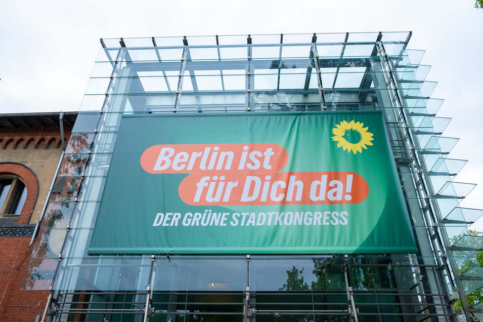 Ein Blick auf den Veranstaltungsort außen, ein großes Banner mit der Aufschrift "Berlin ist für dich da" hängt an einem Gebäude