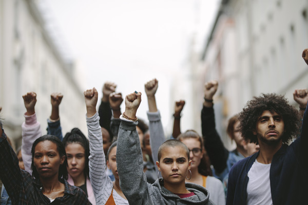 Menschen auf einer Demonstration strecken die Arme in die Luft Getty