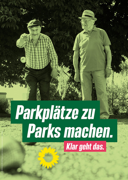 Zwei ältere Herren stehen nebeneinander auf dem Asphalt eines Parkplatzes und spielen Boule. Im Hintergrund sind Büsche und Bäume. Die Bildaufschrift lautet "Parkplätze zu Parks machen. Klar geht das.". Darunter ist das Logo von Bündnis 90/Die Grünen abgebildet. 