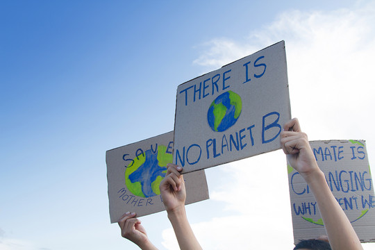 Menschen halten Schilder auf denen steht "Es gibt keinen Planet B" piyaset via Getty Images