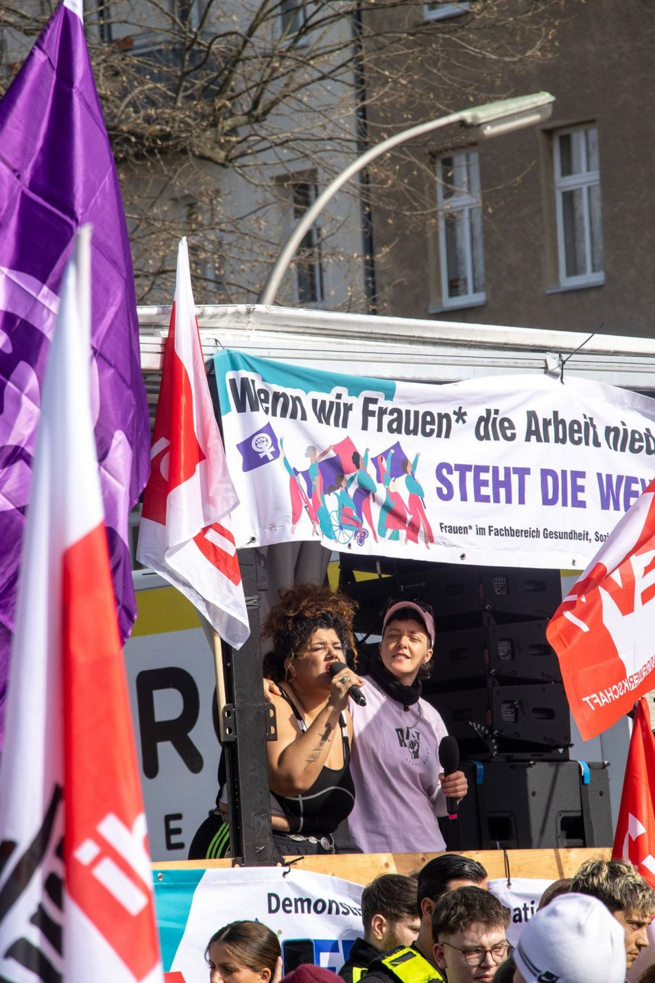 Ein Blick auf die Kundgebung zum 8. März am Oranienplatz. Mehrere Personen stehen auf einer Bühne.