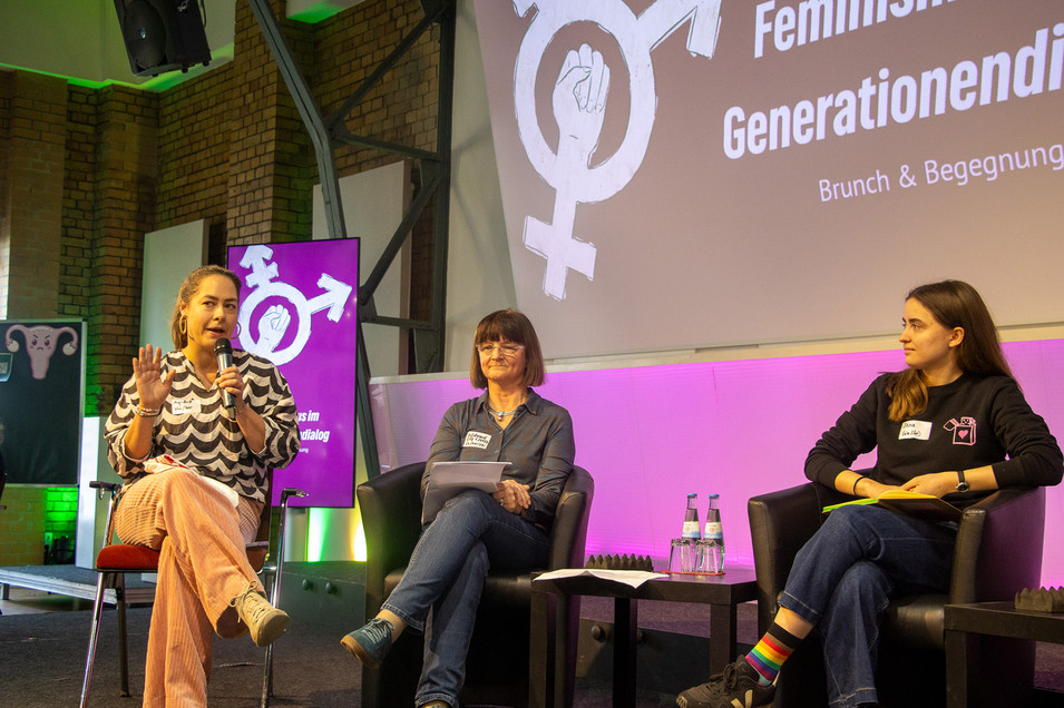 Mehrere Personen sitzen auf einer Bühne nebeneinander