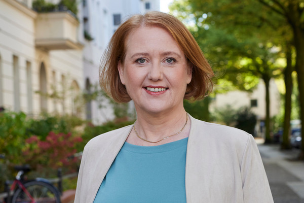 Portrait von Lisa Paus mit freundlichem Gesichtsausdruck vor einer Berliner Straße. Foto: Laurence Chaperon