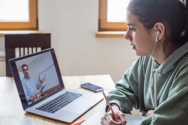 Ein Mädchen sitzt vor einem Laptop und schaut eine online Vorlseung an Getty