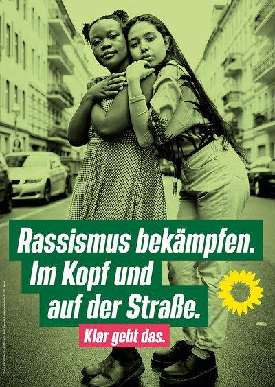 Zwei junge BIPoC stehen auf der Mitte einer Straße in Berlin. Eine legt Kopf und Hände auf die Schulter der anderen. Die Bildaufschrift lautet "Rassismus bekämpfen. Im Kopf und auf der Straße. Klar geht das.". Daneben ist das Logo von Bündnis 90/Die Grünen abgebildet. © Bündnis 90/Die Grünen