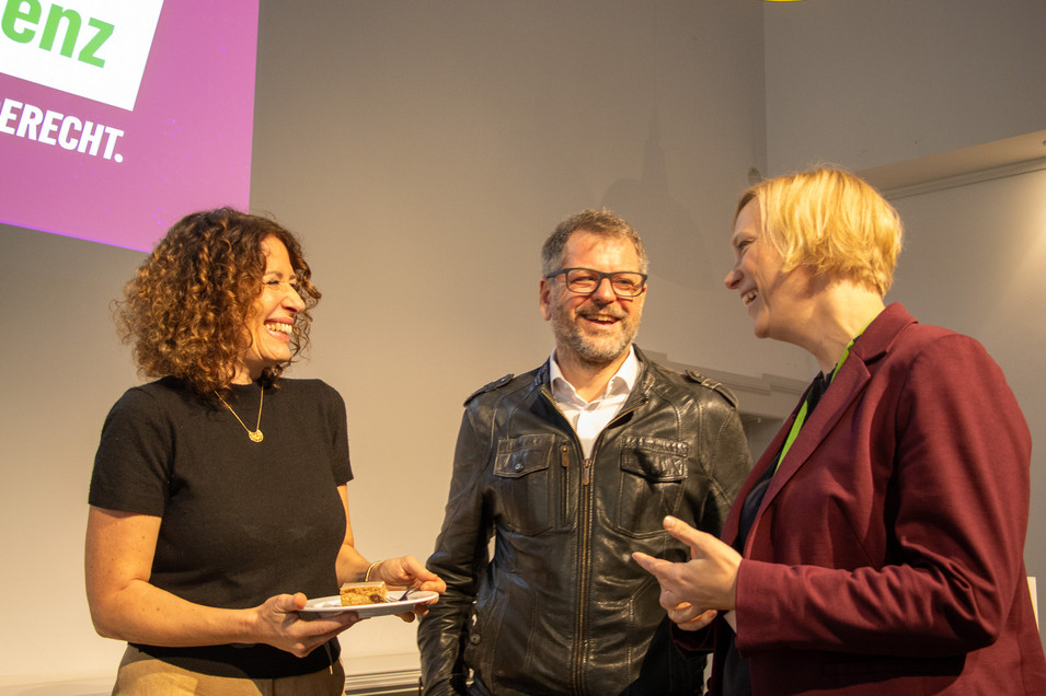 Bettina Jarasch, Werner Graf und Nina Stahr stehen nebeneinander und sind im Gespräch vertieft.