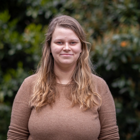 Portrait von Jana Brix, Mitglied im Landesvorstand von Bündnis 90/Die Grünen Berlin, vor einer grünen Pflanzenwand Foto: Bündnis 90/Die Grünen Berlin